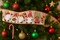 Designer’s Shop WR 63-5203 Christmas Gnome Wired Edge Ribbon – 2.5" x 10 Yards – Red Green Striped Hats & Holiday Lanterns on Natural Burlap
